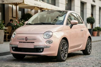 Fiat 500 rose gold garée dans une rue européenne pavée, vue en trois quarts avant avec finition métallisée pastel