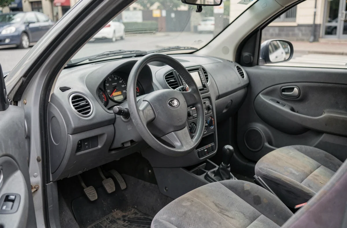 Intérieur d'une voiture sans permis d'occasion avec tableau de bord compact et siège conducteur usagé