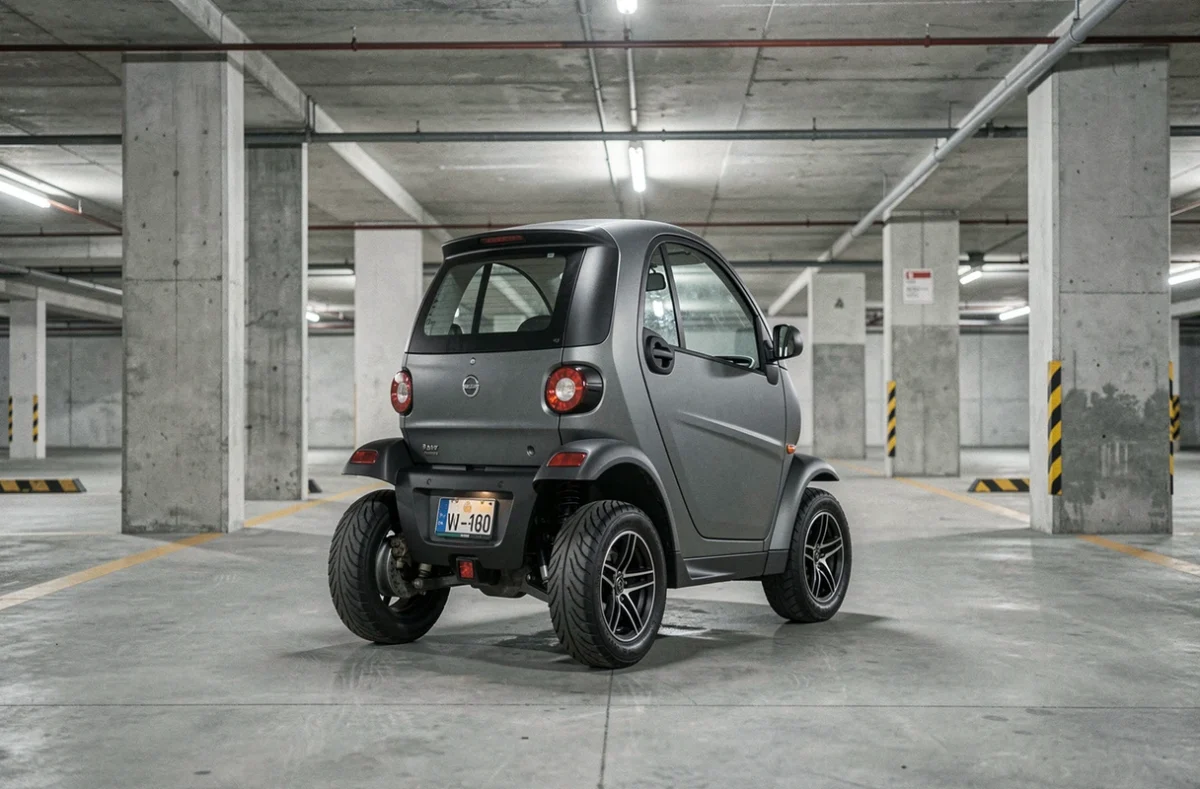 Mini voiture sans permis électrique garée dans un parking souterrain urbain montrant son gabarit compact