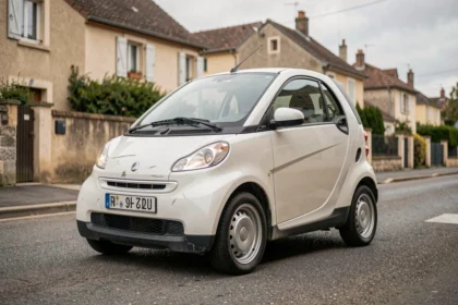 Petite voiture sans permis d'occasion garée dans une rue résidentielle française, vue en angle 3/4 avant